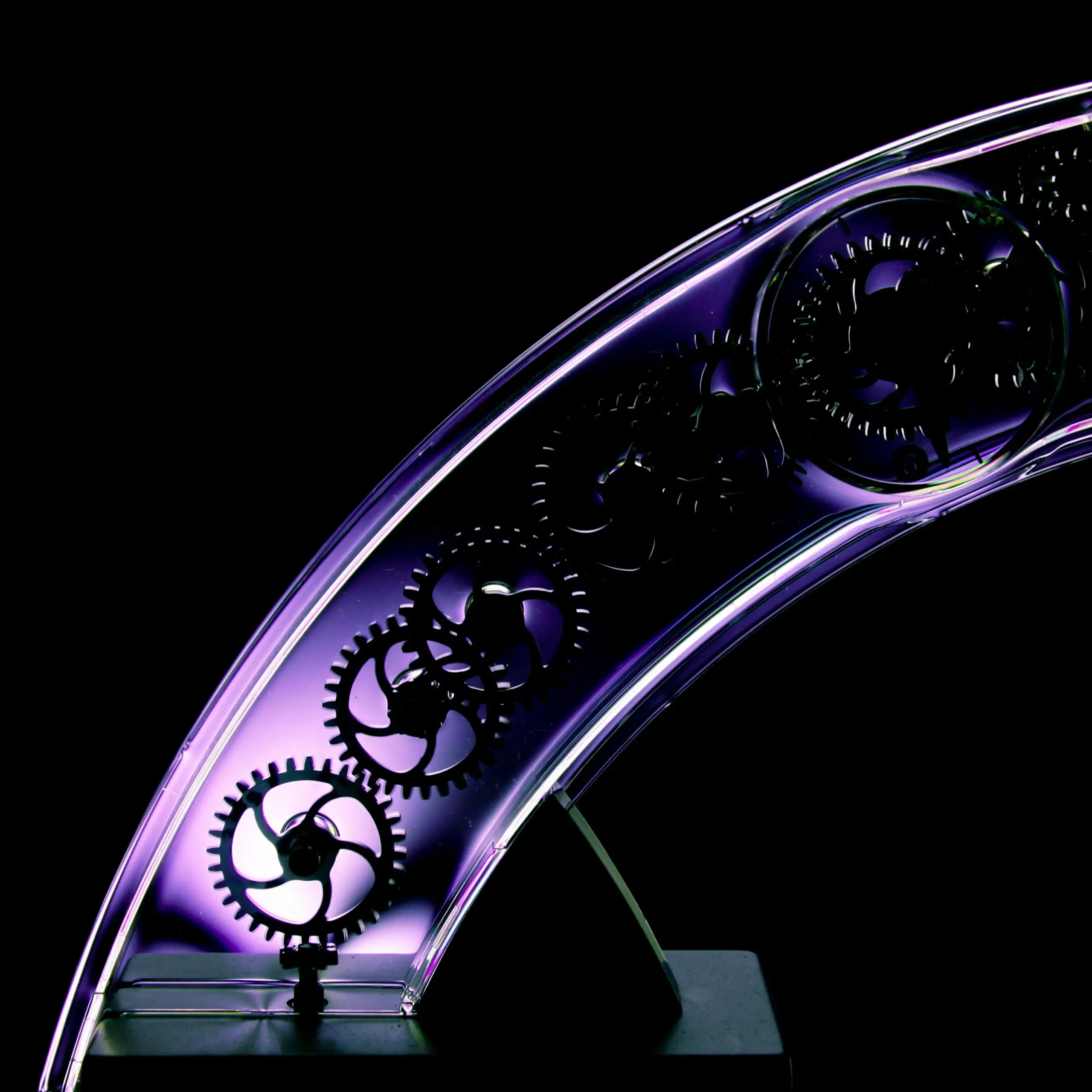 Futuristic transparent gear structure illuminated with purple lighting
