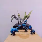 Mechanical mantis surrounded by small blue robotic pets
